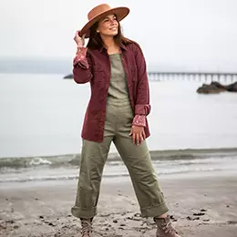 Woman standing on rocky beach wearning Old Ranch Brands pants.